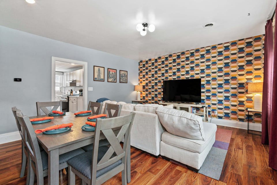 Bring everyone together in this open-concept living and dining space, featuring a large sectional, smart TV, and spacious dining area—perfect for movie nights, shared meals, and making lasting memories with family and friends.