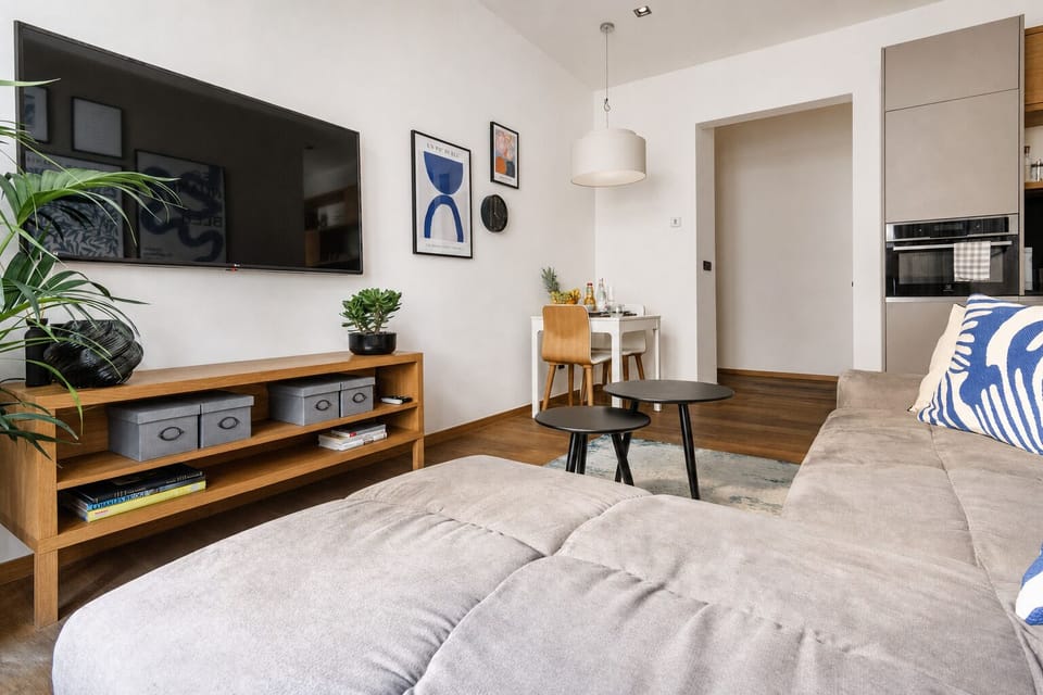 Bright modern lounge with sectional sofa, TV, and cozy dining nook