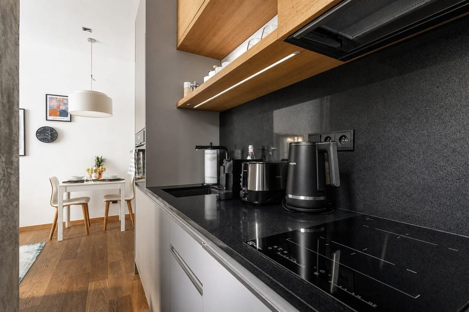 Sleek modern kitchen with black stone finishes and cozy dining nook