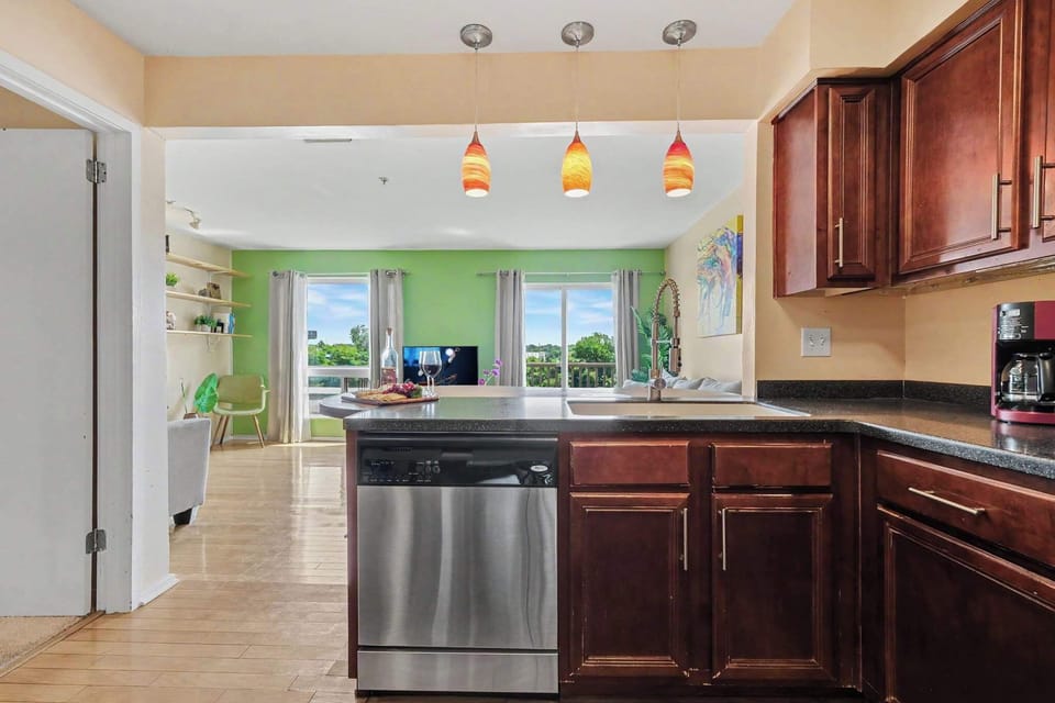 Spacious kitchen with stainless steel appliances, generous counter space, and a breakfast bar with seating for four.