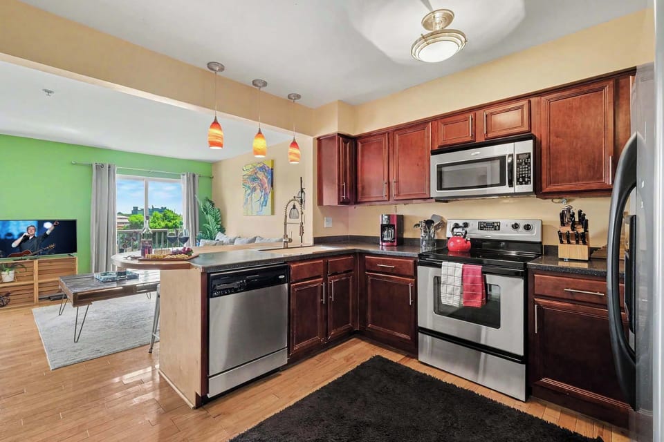 Spacious kitchen with stainless steel appliances, generous counter space, and a breakfast bar with seating for four.