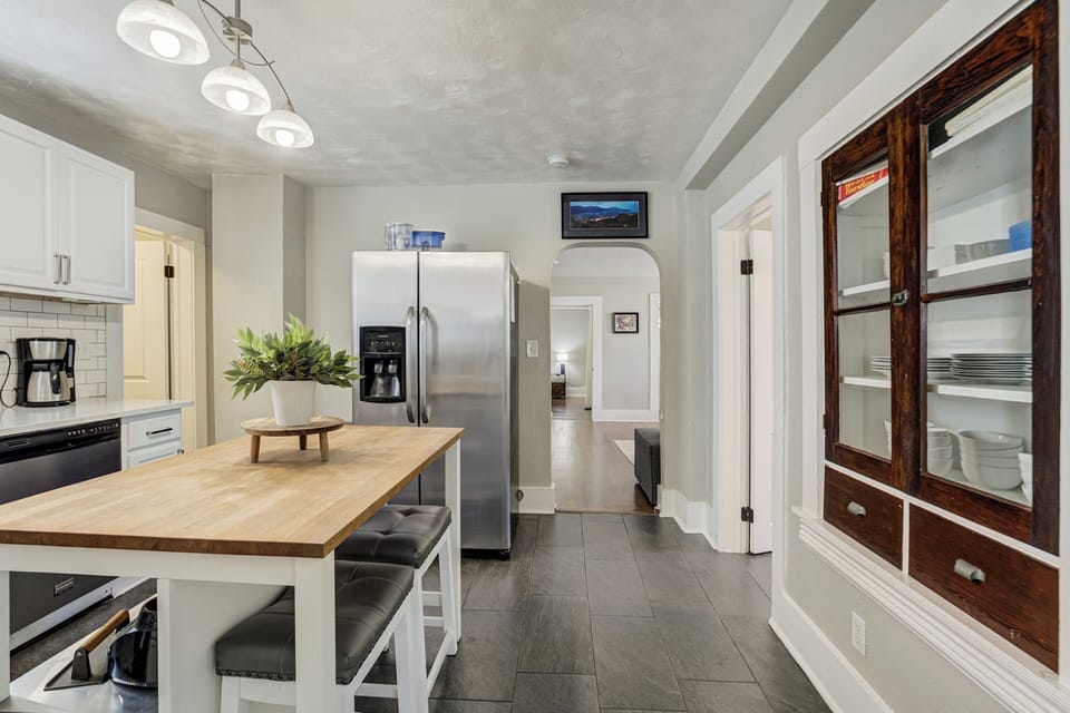 The fully stocked kitchen includes cookware, dishes, full-size appliances, dishwasher, kitchen island seating, and a coffee bar with starter coffee provided.