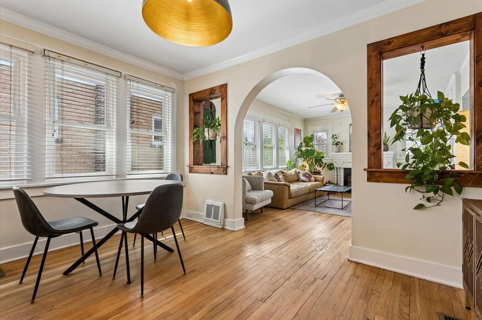 Architectural detail of a classic archway flanked by custom wood-framed interior windows with hanging greenery.