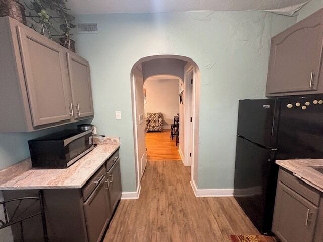 Charming galley kitchen with modern finishes, arched entry to dining.