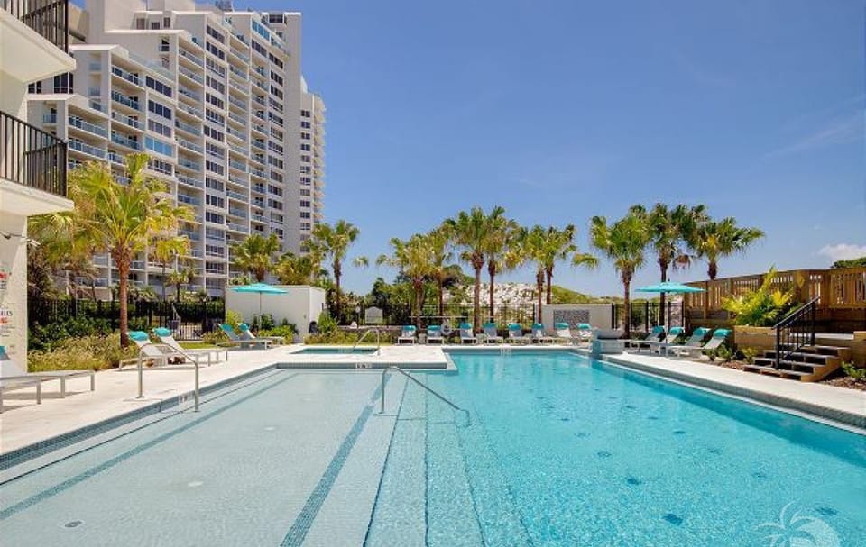 Pool deck with lounge seating and palm trees