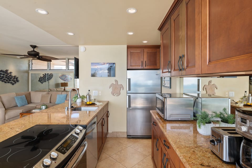 Spacious kitchen with breakfast bar seating, stainless appliances, and open flow into the living area.