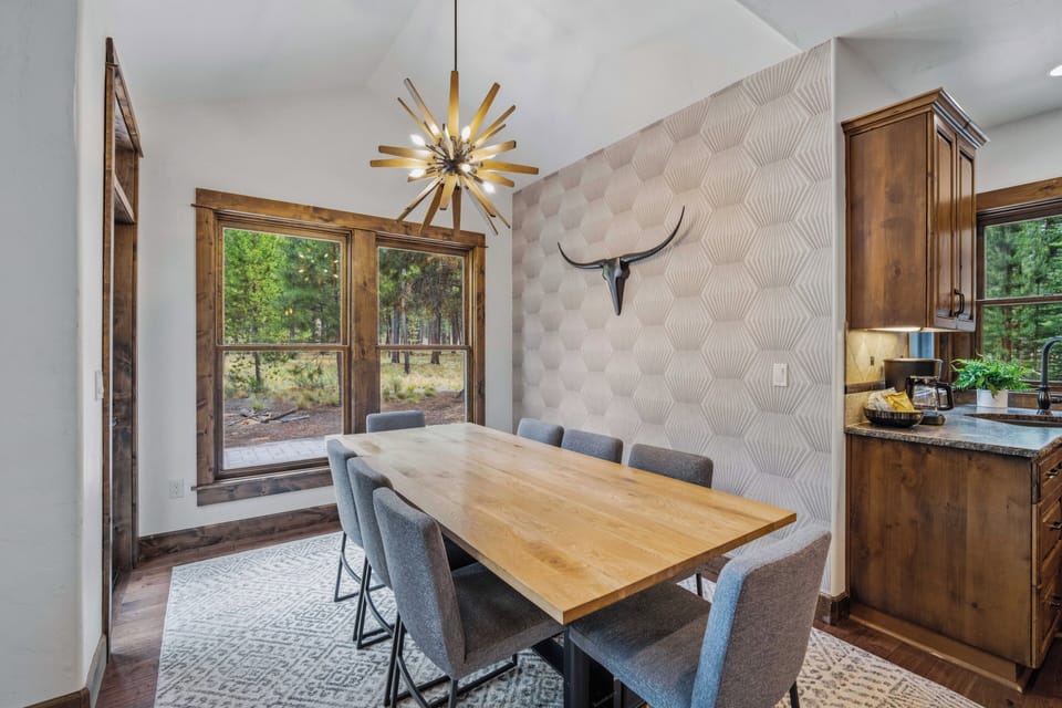 Gather around this stylish dining space, where forest views through the windows and modern design touches create the perfect setting for your memorable meals together.
