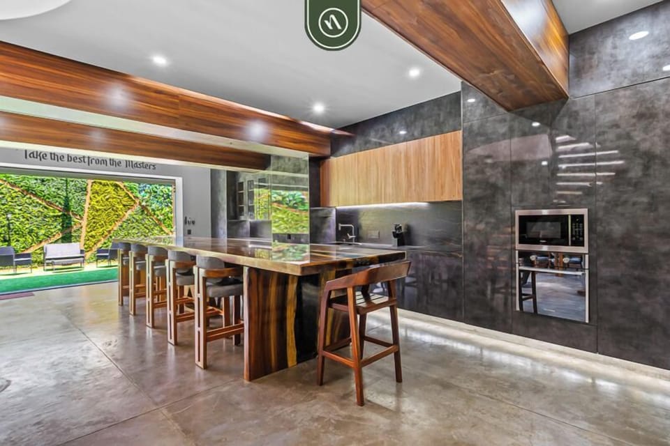 Sleek modern kitchen with an extended bar-height counter and stylish seating. Fully equipped with premium finishes, this open space is perfect for cooking, casual dining, and socializing.
