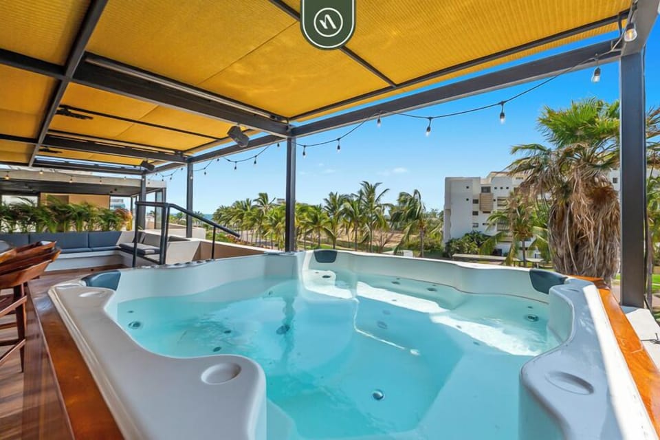 Relax in a private jacuzzi with stunning mountain and palm views. Shaded lounge area with string lights creates the perfect spot to unwind, soak, and enjoy peaceful sunsets in a tropical setting.