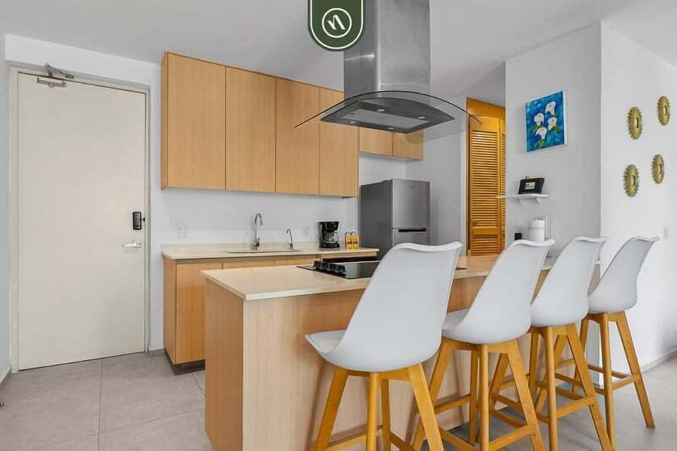 Modern kitchen with clean finishes, fully equipped appliances, and a stylish breakfast bar with seating. Perfect for casual meals, morning coffee, or socializing while cooking.