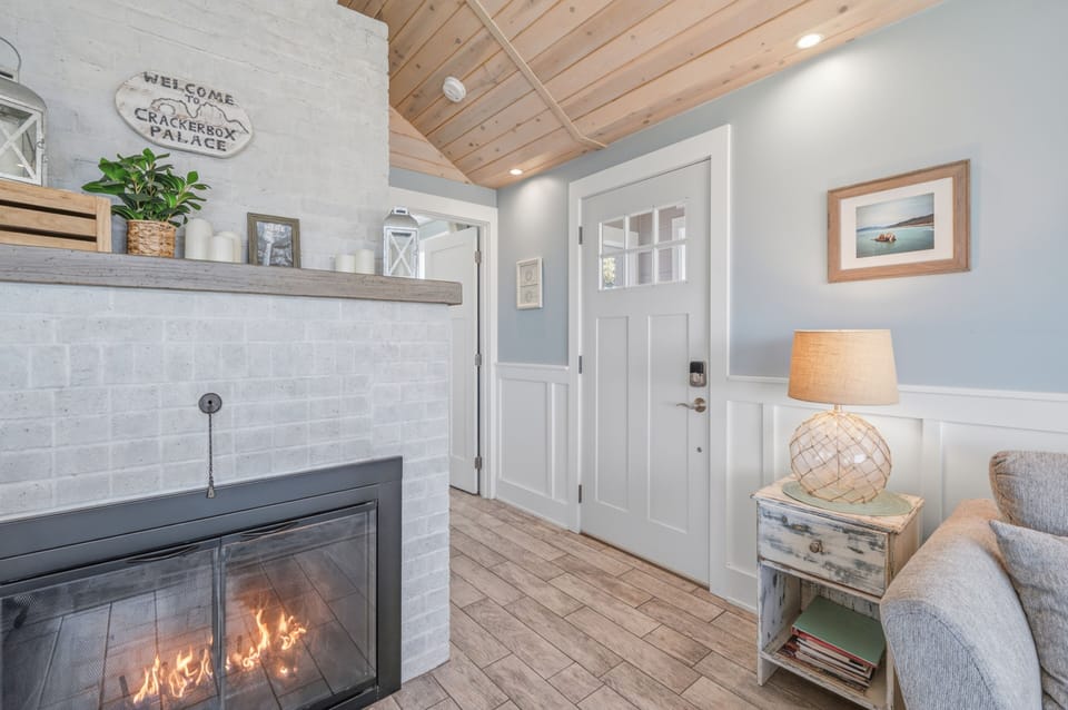 Step into a bright, welcoming space where coastal charm meets cozy comfort. The crackling fireplace and vaulted wood ceilings create an inviting retreat after your day's adventures.
