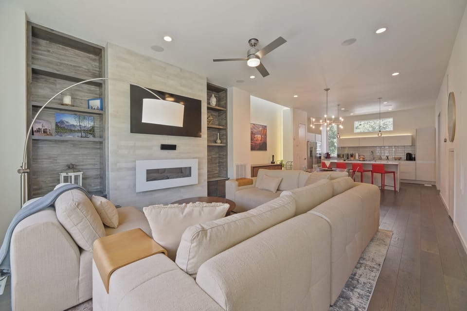 Sink into plush seating while your favorite show plays on the mounted TV. Stylish built-ins frame the modern fireplace, and the open layout connects you to the kitchen for easy entertaining.