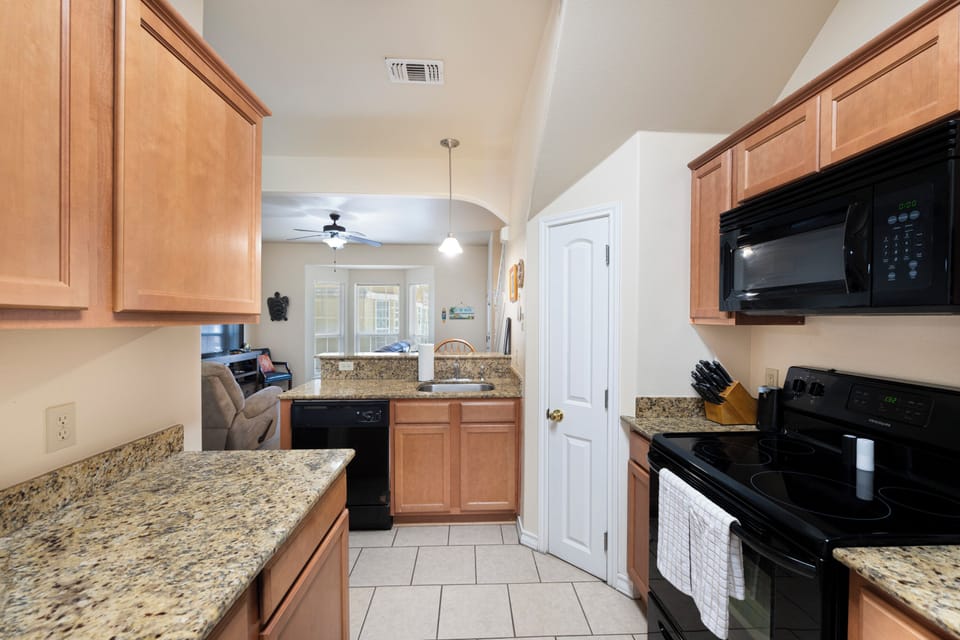 Your fully equipped kitchen with granite counters and modern appliances makes meal prep a breeze, with open views into the living area for easy conversation.