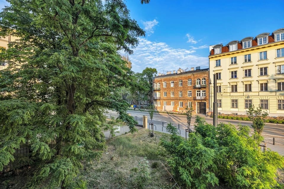 Green Neighborhood View with Historic Architecture & Tree-Lined Streets | Book Now with RENTUJEMY.COM