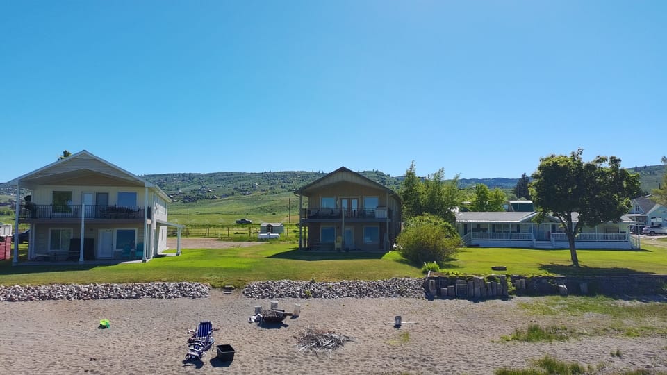 Beachfront home with sandy shore, fire pit, and peaceful hill views