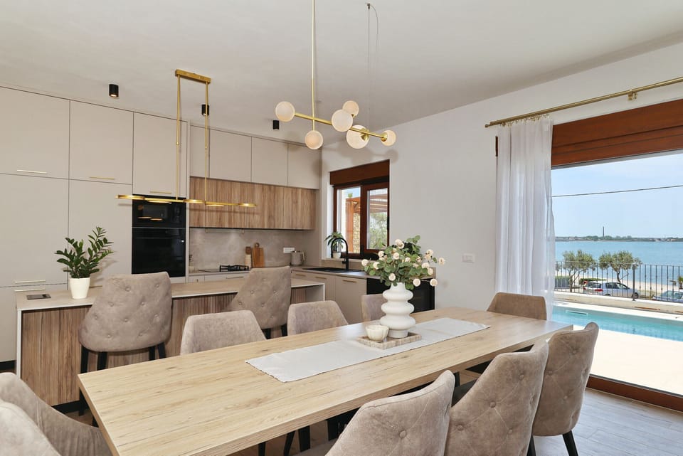 Modern open kitchen of Villa Diaria with dining area and beautiful sea view.