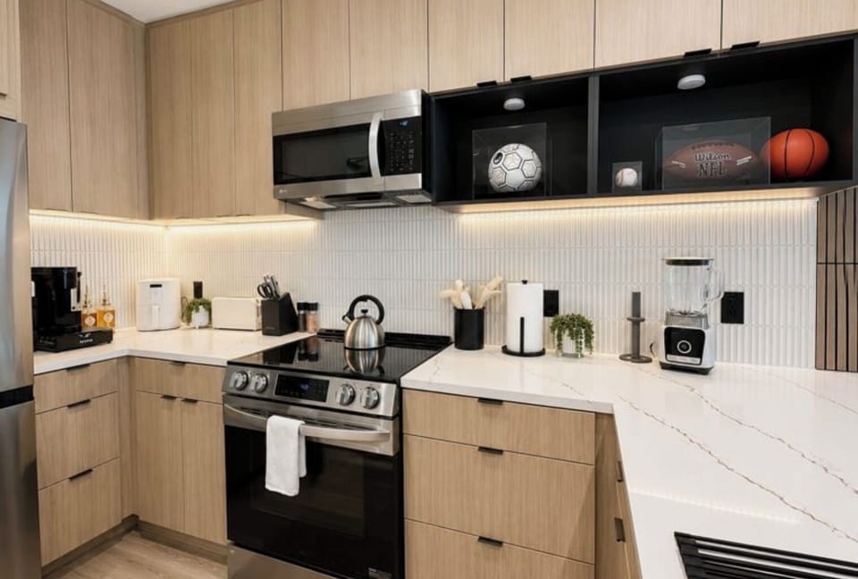 Stylish modern kitchen with quartz counters, stainless appliances, and warm lighting
