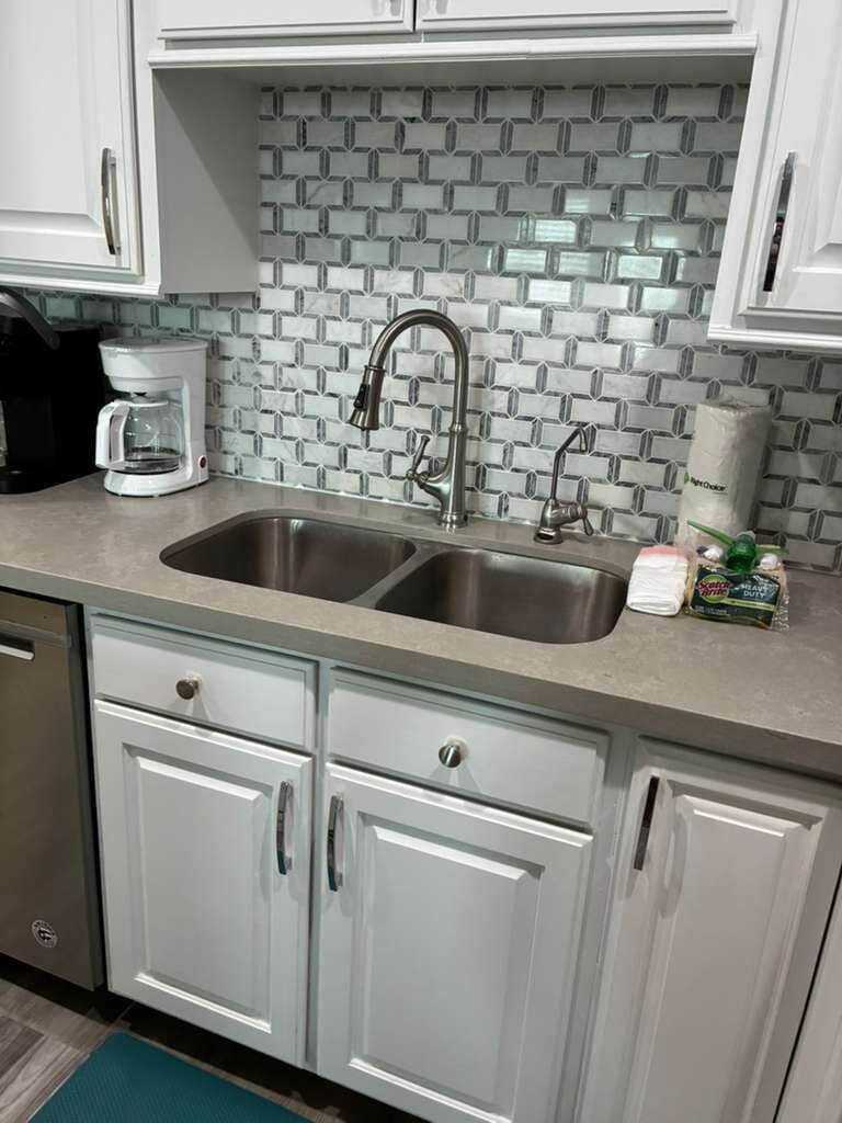 Bright updated kitchen with double sink and stylish tile backsplash