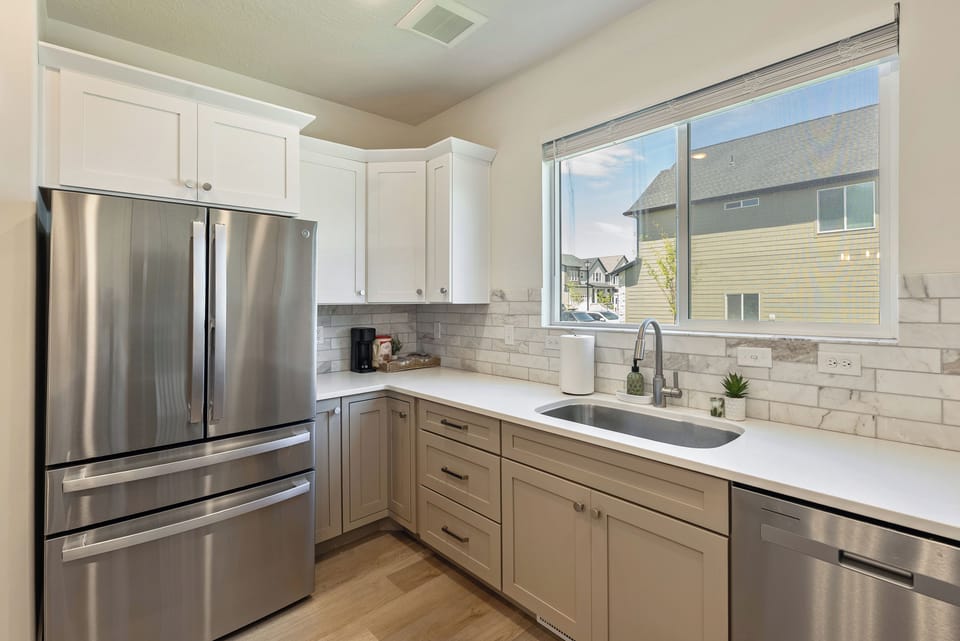 Bright modern kitchen with stainless appliances and large sunny window