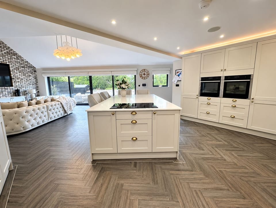 Open-plan kitchen featuring two built-in ovens, wine fridge, full-height fridge and freezer, instant hot water tap, induction hob, and all cooking essentials provided, including herbs, oils, and kitchen utensils – everything you need to cook and entertain with ease.