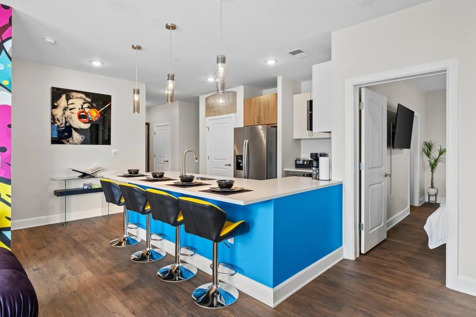- Sleek open kitchen with bright blue island  
- Modern appliances perfect for cooking  
- Bar seating ideal for group travel  
