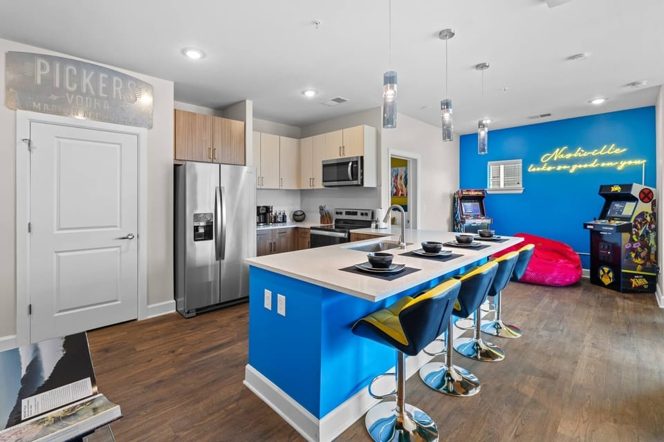- Modern kitchen with bright blue island and bar seating 
- Stainless appliances and stocked cooking essentials 
- Ideal setup for long stays near local attractions 
