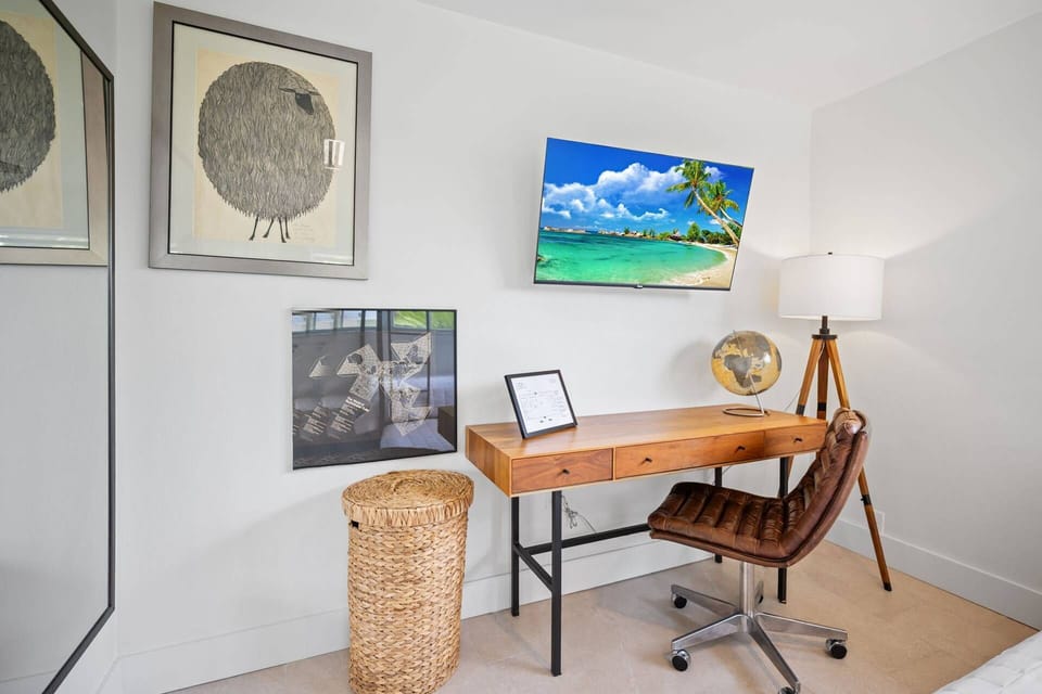 Dedicated workspace with desk, chair, smart TV, and natural light for remote work
