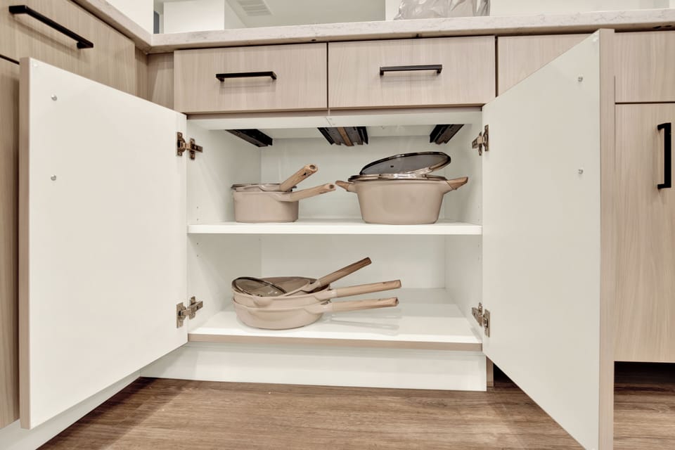 Organized modern kitchen cabinet stocked with cookware for easy meals