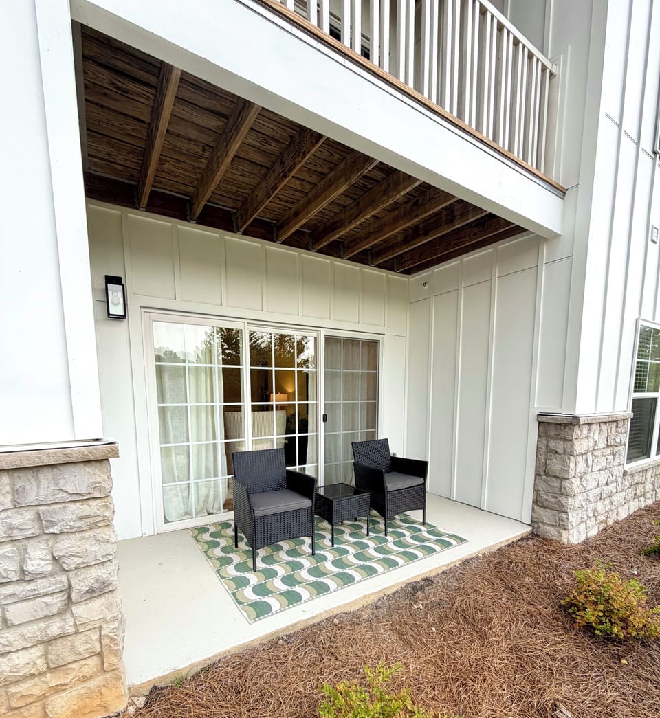 Private covered patio with cozy seating just outside the sliding doors