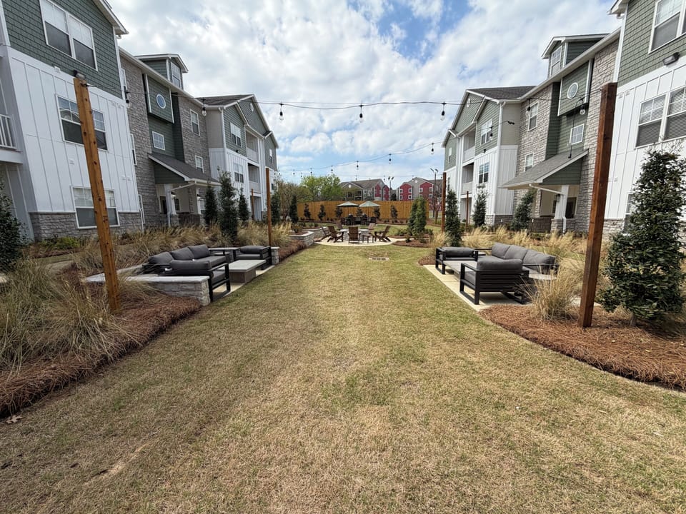 Inviting landscaped courtyard with lounge seating and café lights