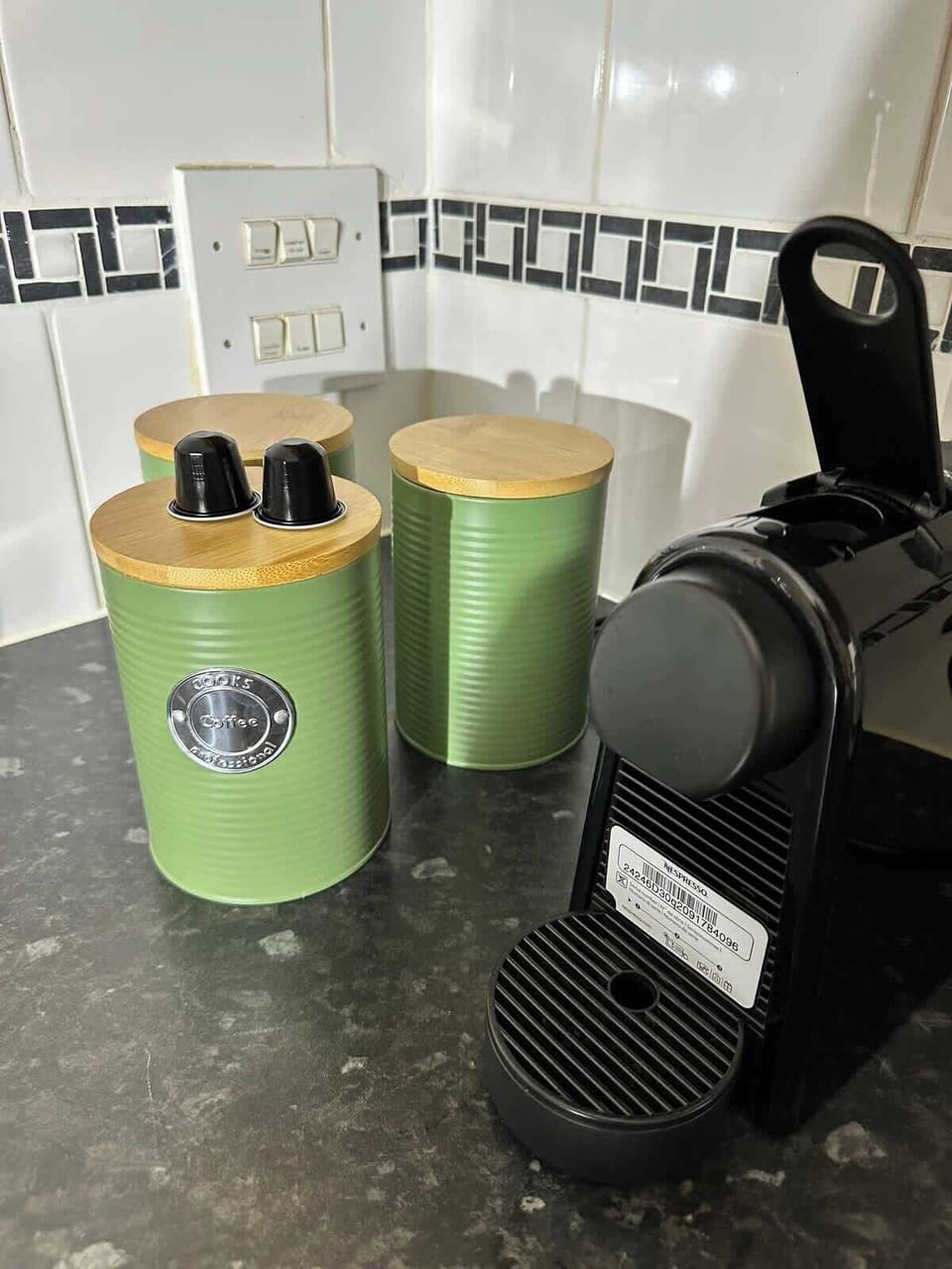 Your morning sorted — a Nespresso coffee machine sits beside stylish green bamboo-lidded canisters stocked with coffee pods and tea. Start each day with a proper brew in the comfort of the apartment.