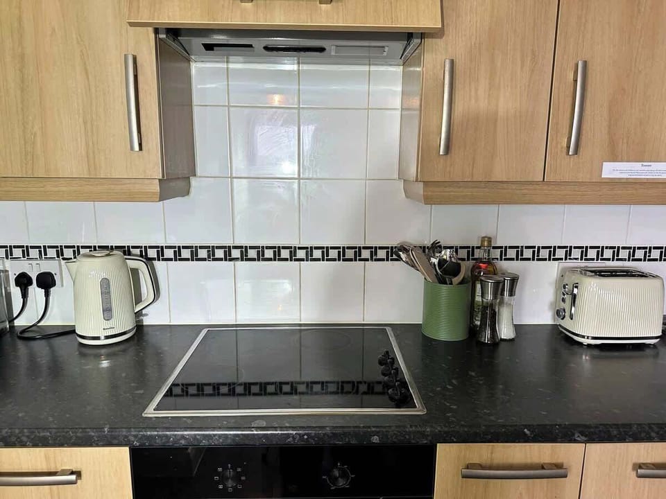 Cook with ease on the sleek 4-ring ceramic hob, set flush into the dark granite worktop. The kitchen is fully equipped with a kettle and all the essentials — everything you need to prepare a home-cooked meal.