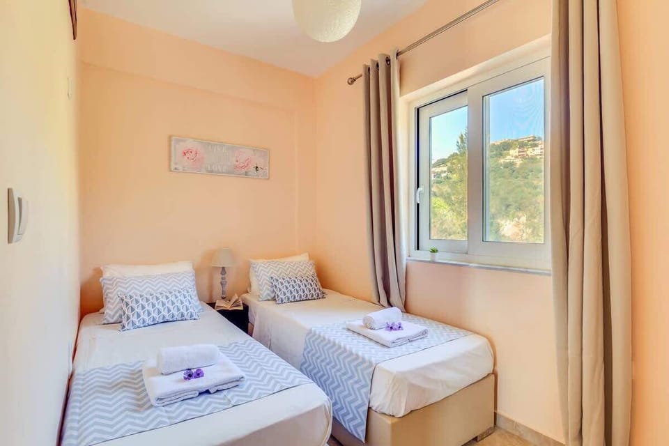 Bright twin bedroom with large windows and beautiful garden views.