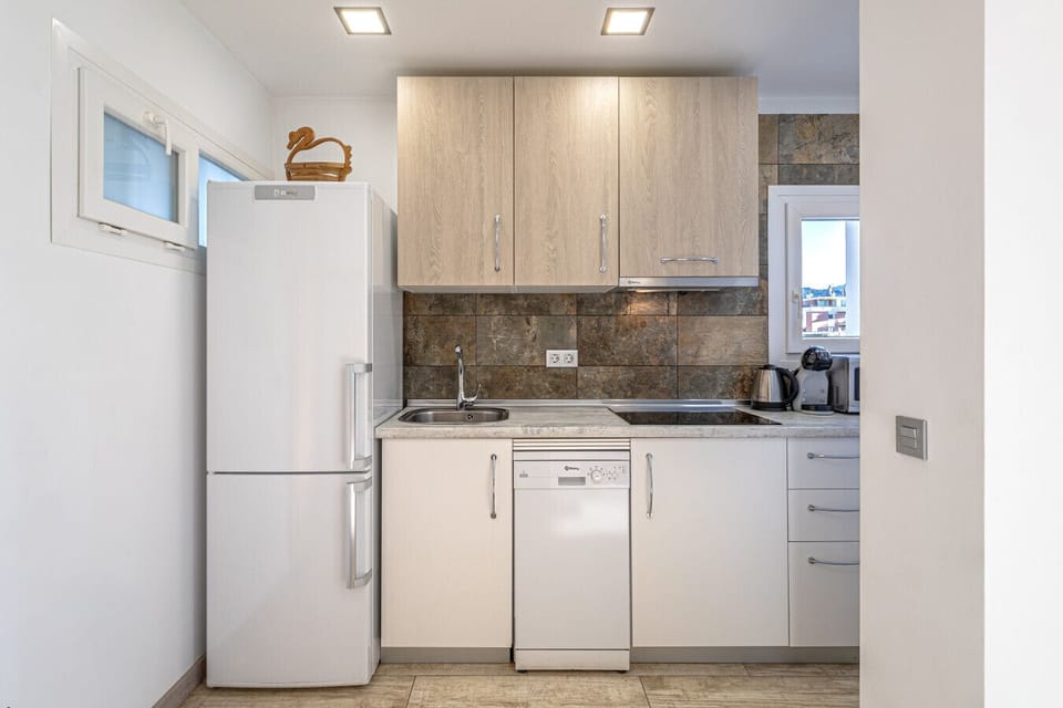 Fully equipped modern kitchen featuring updated appliances, perfect for cooking fresh, local Spanish produce.