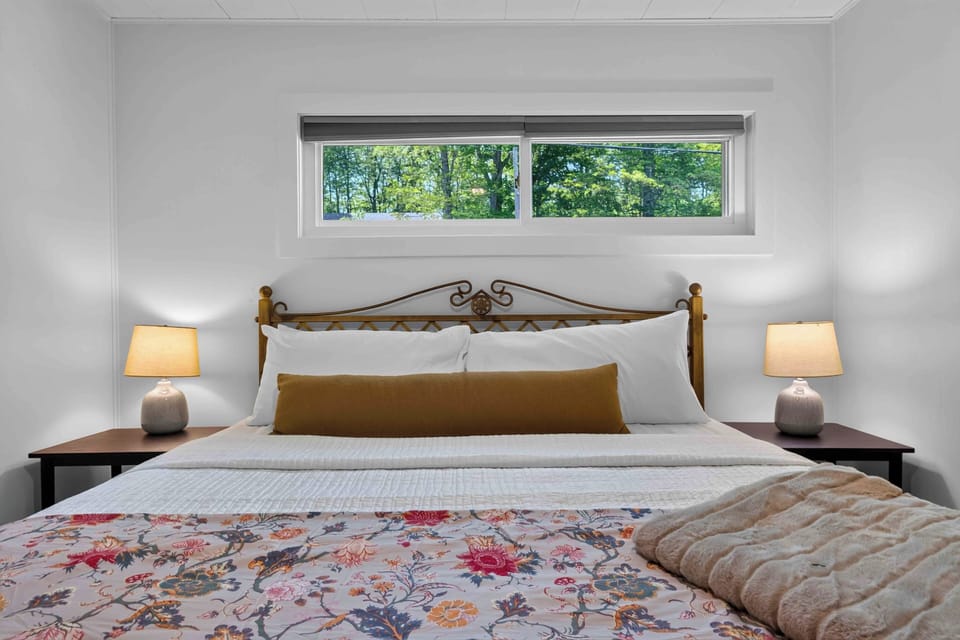 Bedroom 1 with a king bed, soft linens, and peaceful wooded views