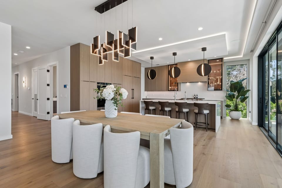 An open-concept dining and kitchen space. Kitchen is appointed with Sub-Zero, Wolf and Cove appliances.