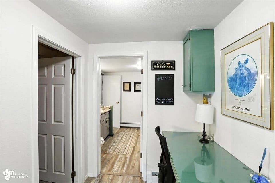 Built-in desk in hallway between kitchen and 1/2bath/laundry room.  Door on left leads to the basement which holds owner's belongings and cleaning supplies, and is kept locked.