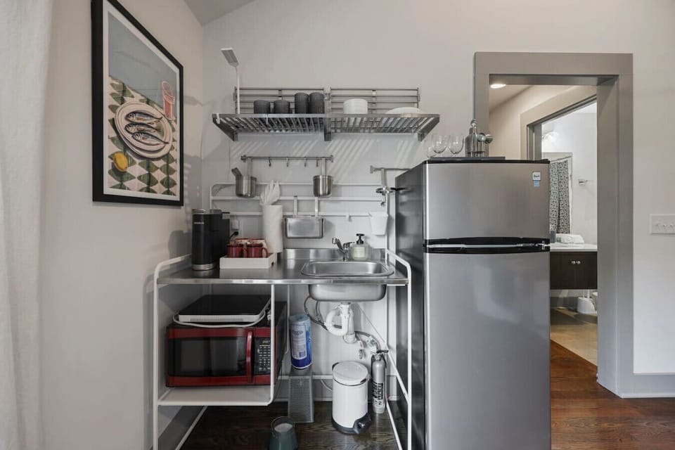 Functional kitchen featuring a microwave, dishware, and a smart, space-saving layout.