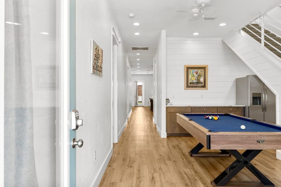 1st Floor-Game room featuring a full-size pool table, wet bar with fridge, and direct access to the backyard—ideal for evenings in with the whole group.