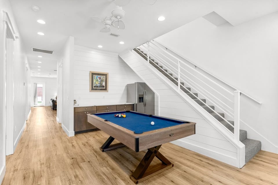 1st Floor-Game room featuring a full-size pool table, wet bar with fridge, and direct access to the backyard—ideal for evenings in with the whole group.