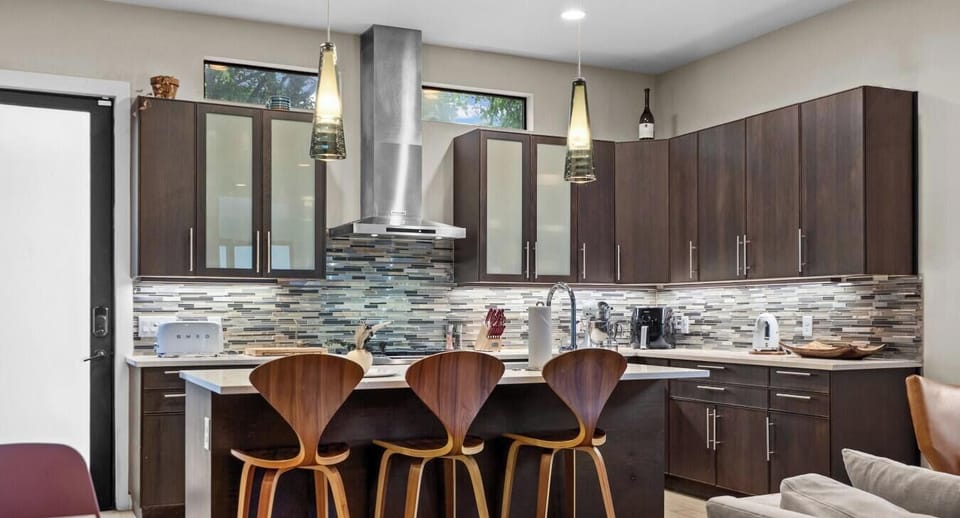 Pull up a barstool at the quartz island and cook with a pro range, glass-tile backsplash, and full counter space for the group.