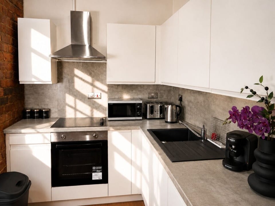 Modern, fully equipped kitchen with oven, hob, microwave, kettle and coffee machine — everything you need for a comfortable stay.