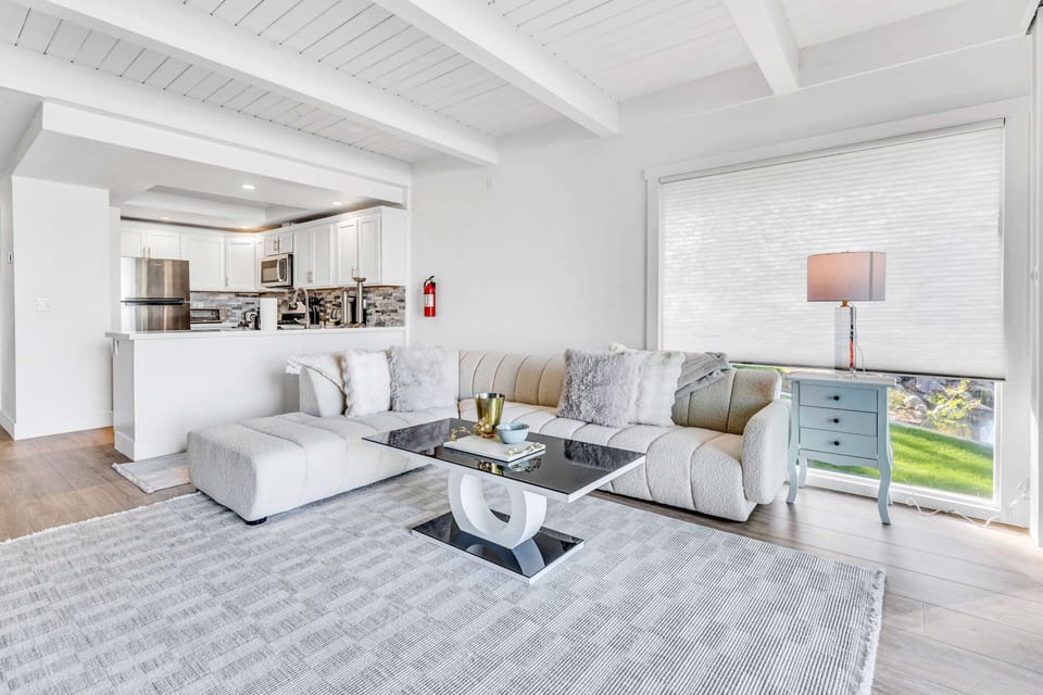 Living room: Standalone gas fireplace, TCL 4K QLED Smart TV, balcony access
