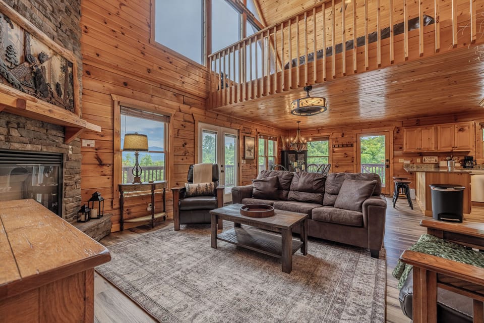 Cozy cabin great room with stone fireplace, loft, and mountain-lodge charm