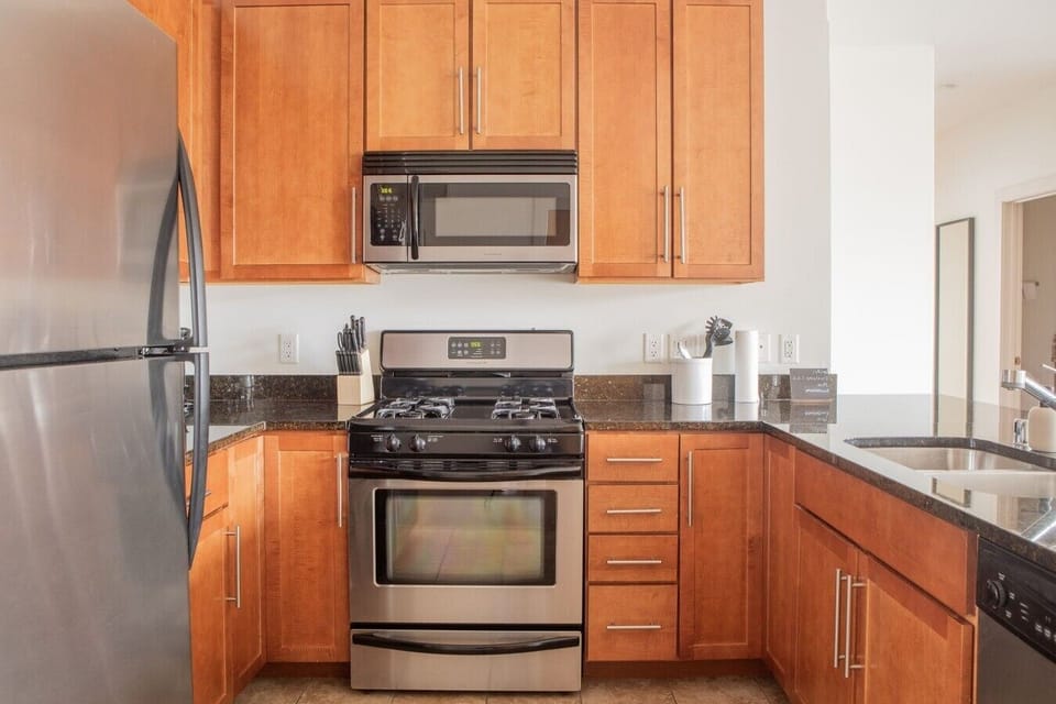The full modern kitchen features stainless steel appliances and bar stool seating, making it easy to whip up morning breakfast or entertain your group