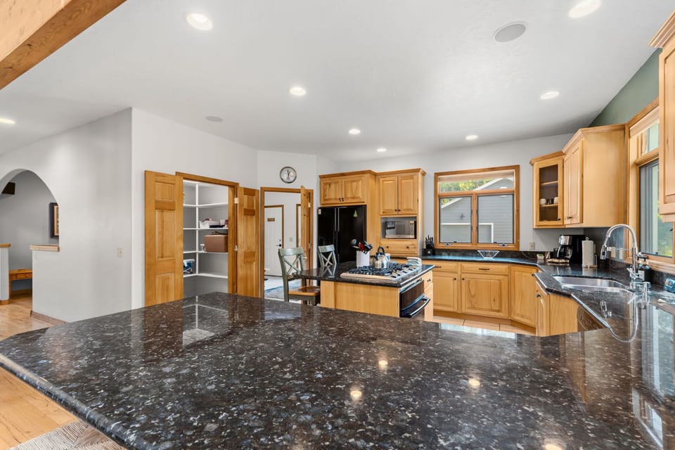 Kitchen: Gas range, drip coffee maker, Keurig coffee machine, Crockpot, blender, kettle, cooking utensils, and tableware