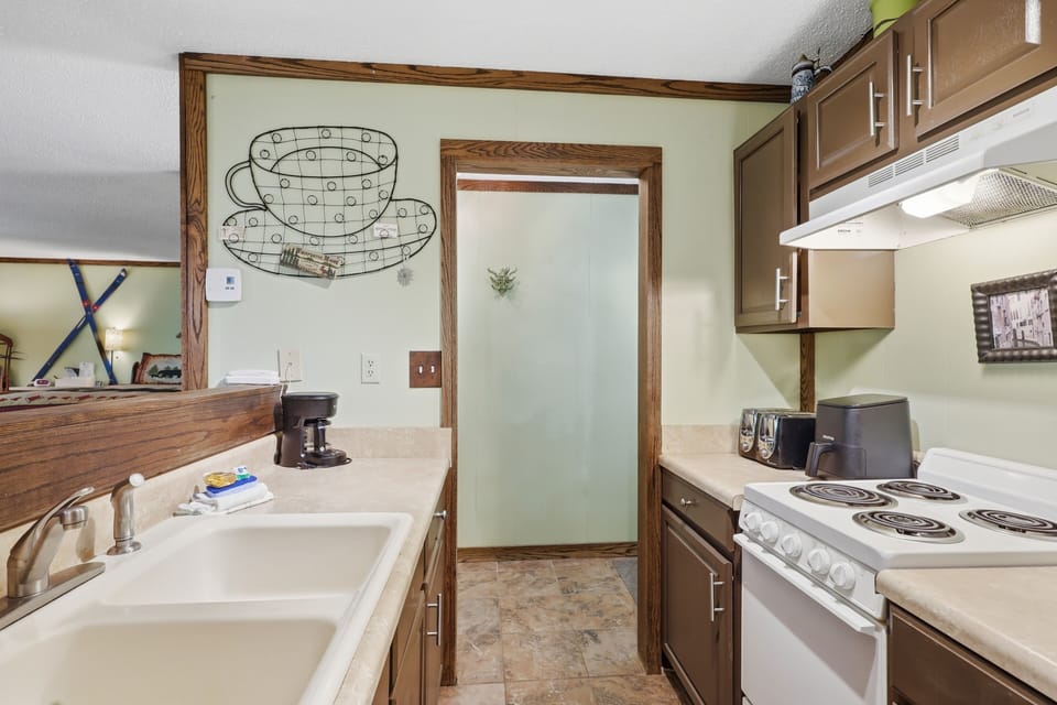 Cozy full kitchen with ample counter space and charming rustic details