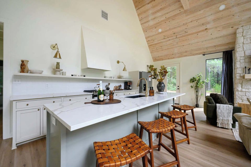 A stunning kitchen with marble counters, gold accents, and soaring wood ceilings — cooking here feels like a treat, not a chore.