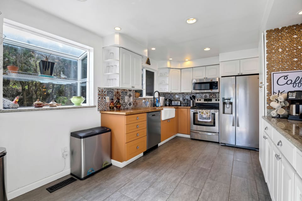 Bright modern kitchen with farmhouse sink and stainless appliances