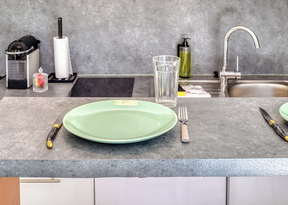 Table avec vaisselle vue sur la cuisine